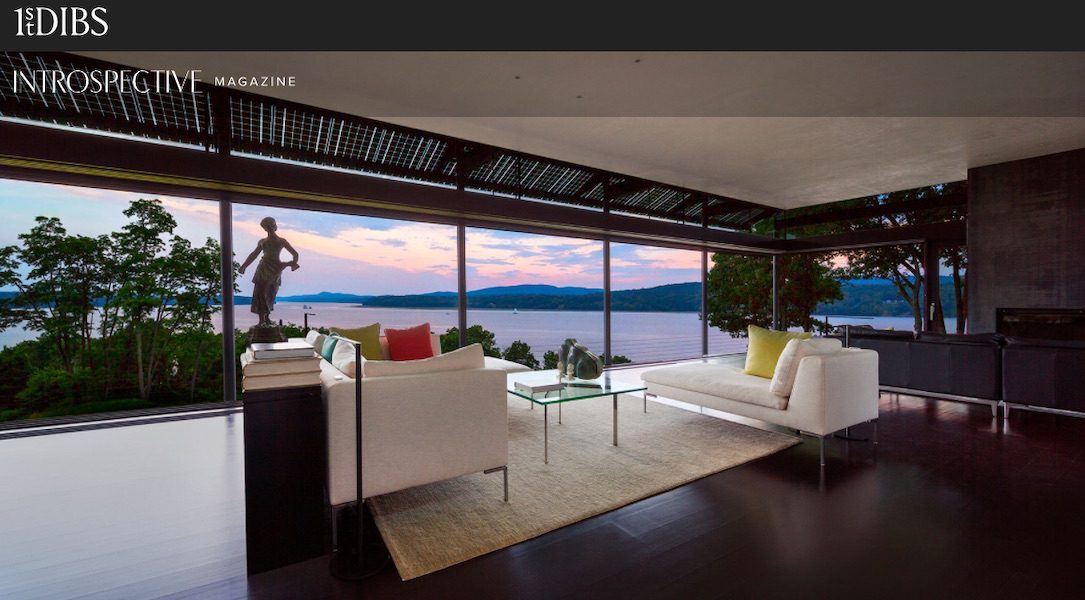 A living room with large windows overlooking a lake.