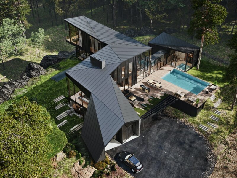 An aerial view of a modern house in the woods.