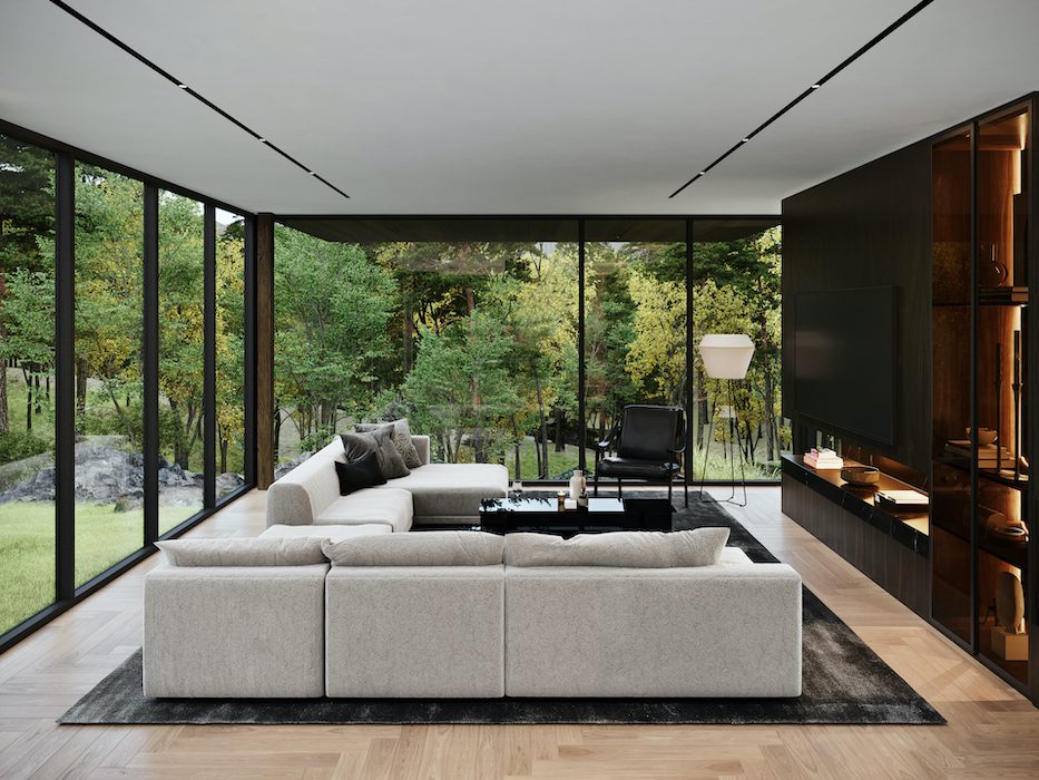 A living room with large windows overlooking a wooded area.