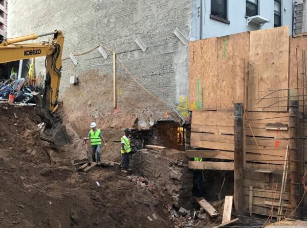 A construction crew is working on a building that has a hole in it.
