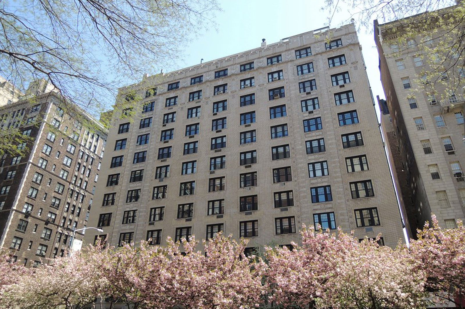 A large building with many windows and trees in the background.