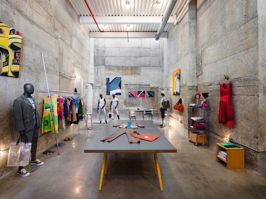 A store with mannequins and clothes on a concrete floor.