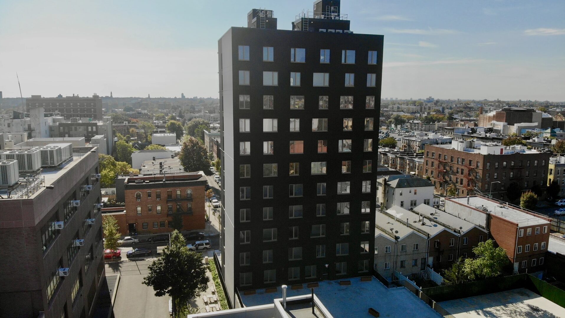 An aerial view of a black building in a city.