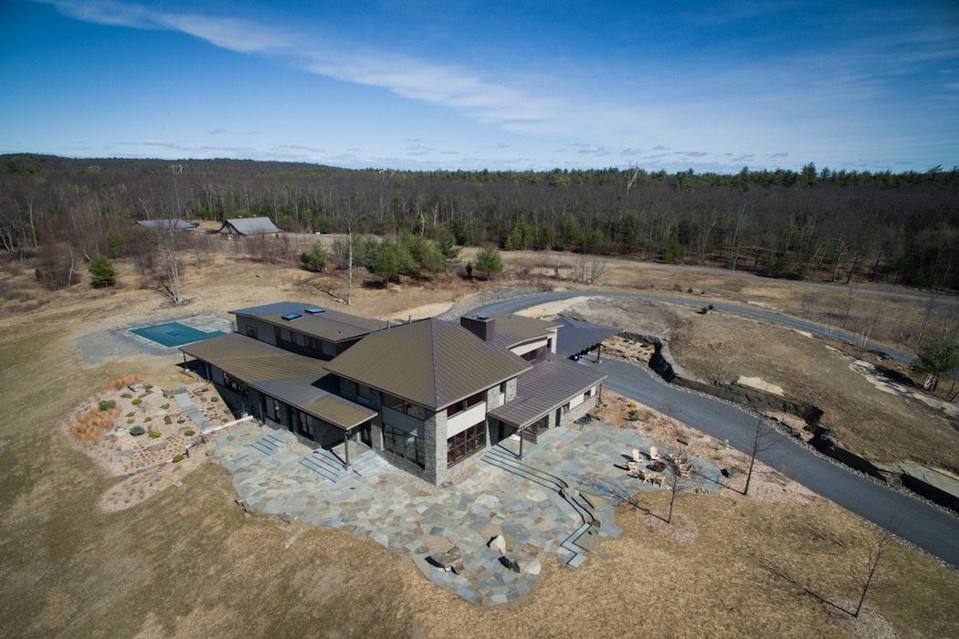 An aerial view of a home in the woods.