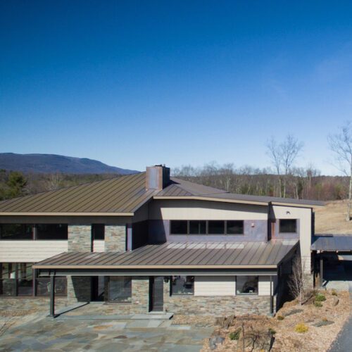 An aerial view of a modern home in the mountains.