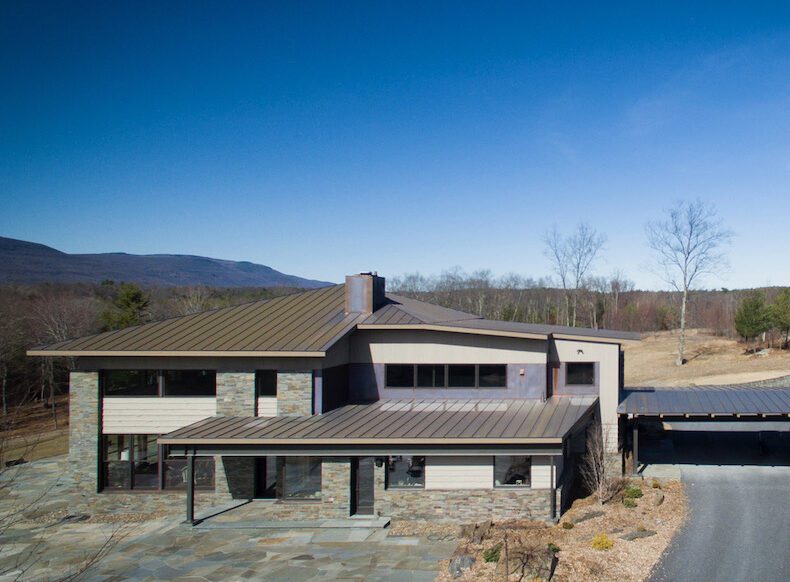 An aerial view of a modern home in the mountains.