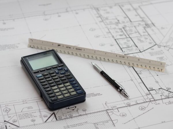 A calculator and a ruler on top of blueprints.