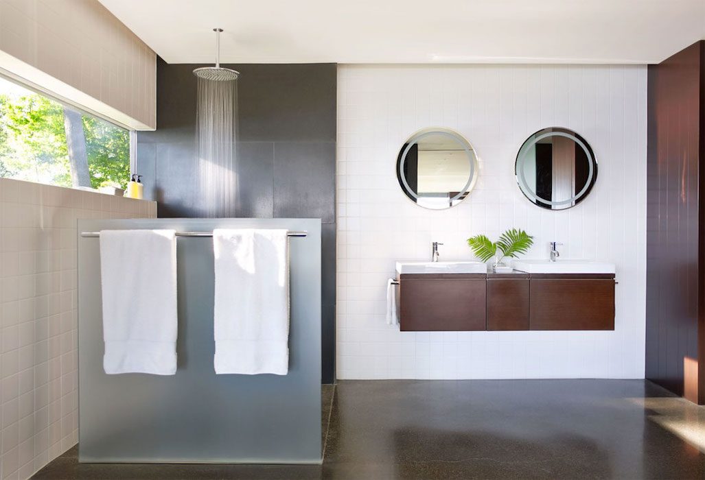 A modern bathroom with two sinks and two mirrors.
