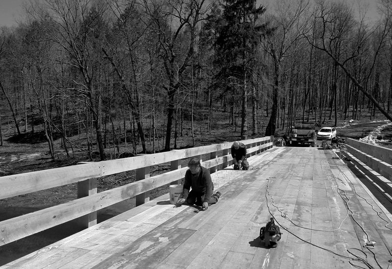 A black and white photo of men working on a bridge.