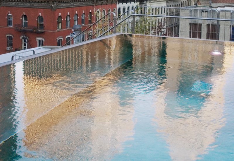 A swimming pool with reflections of buildings on it.