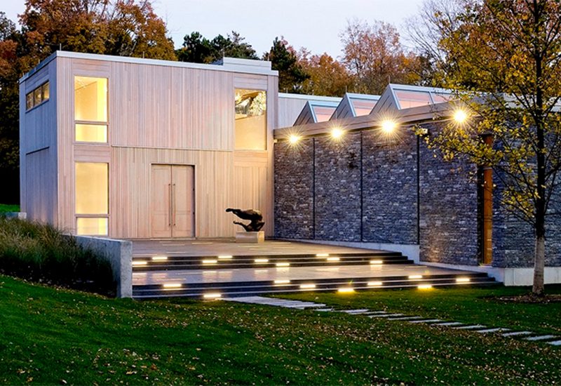 A modern house is lit up at night.