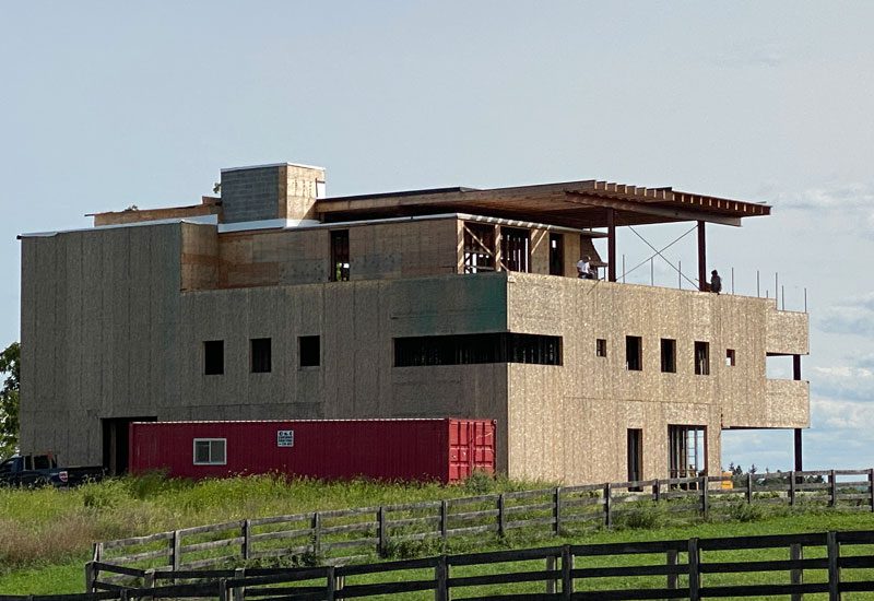 A house is being built in the middle of a field.