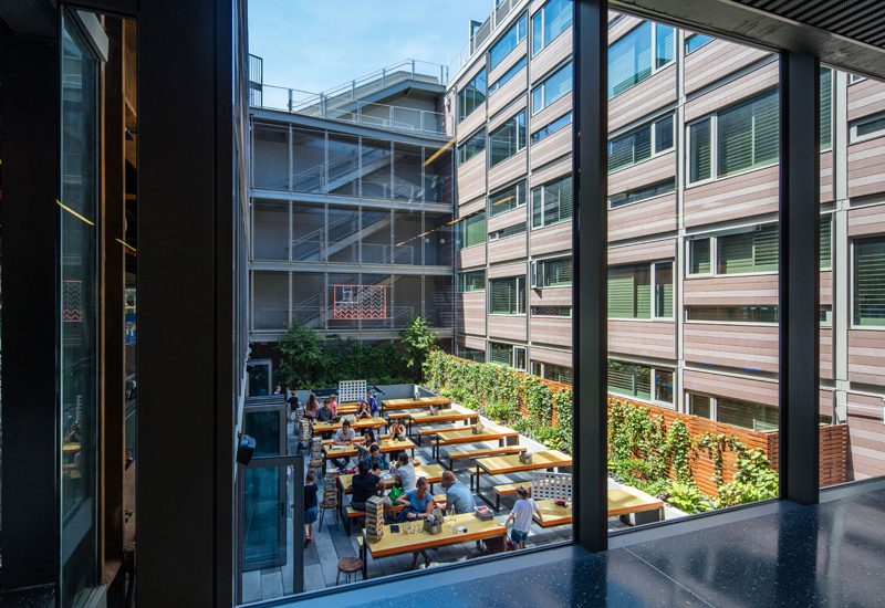 A courtyard with tables and chairs in the middle of a building.