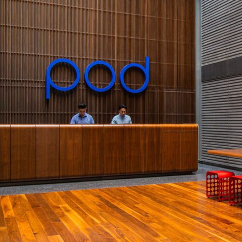A reception area with a wooden floor and a sign that says pod.