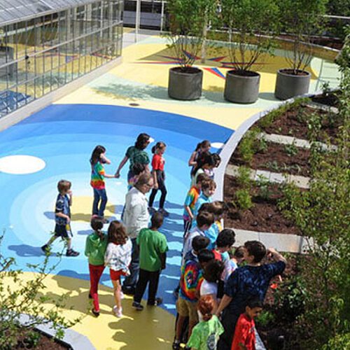 A group of children are standing around a colorful walkway.
