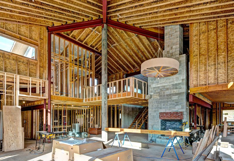 A house under construction with wood framing and a fireplace.