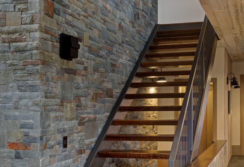 A staircase in a house with a stone wall.