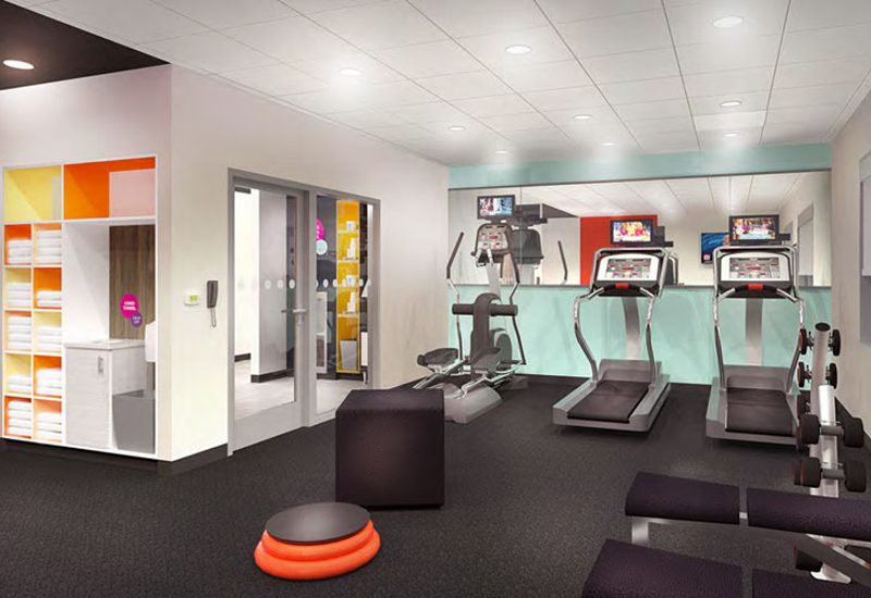 A gym room with a treadmill and other exercise equipment.