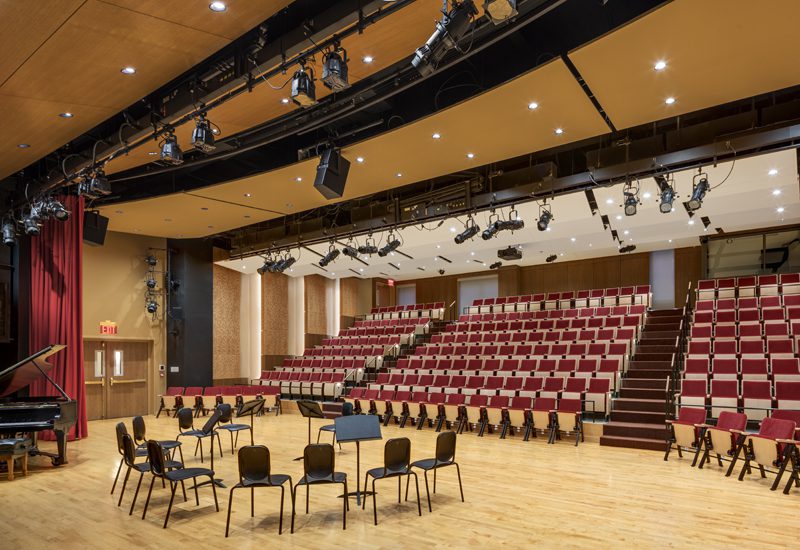 A large auditorium with a stage and chairs.