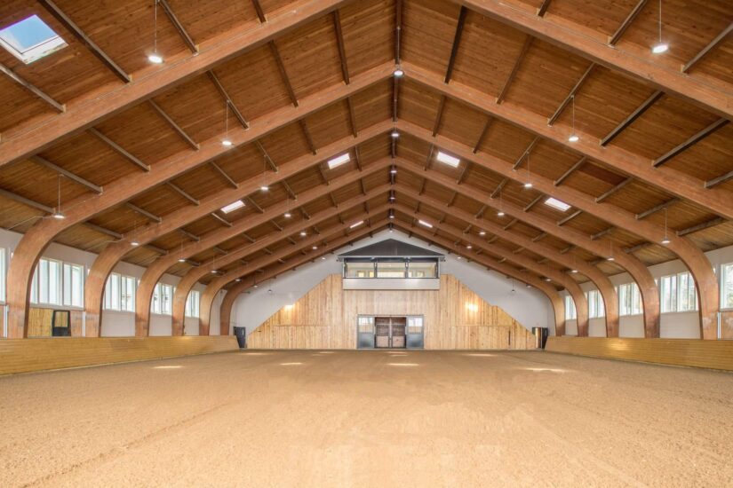 The inside of a horse barn with wooden beams.
