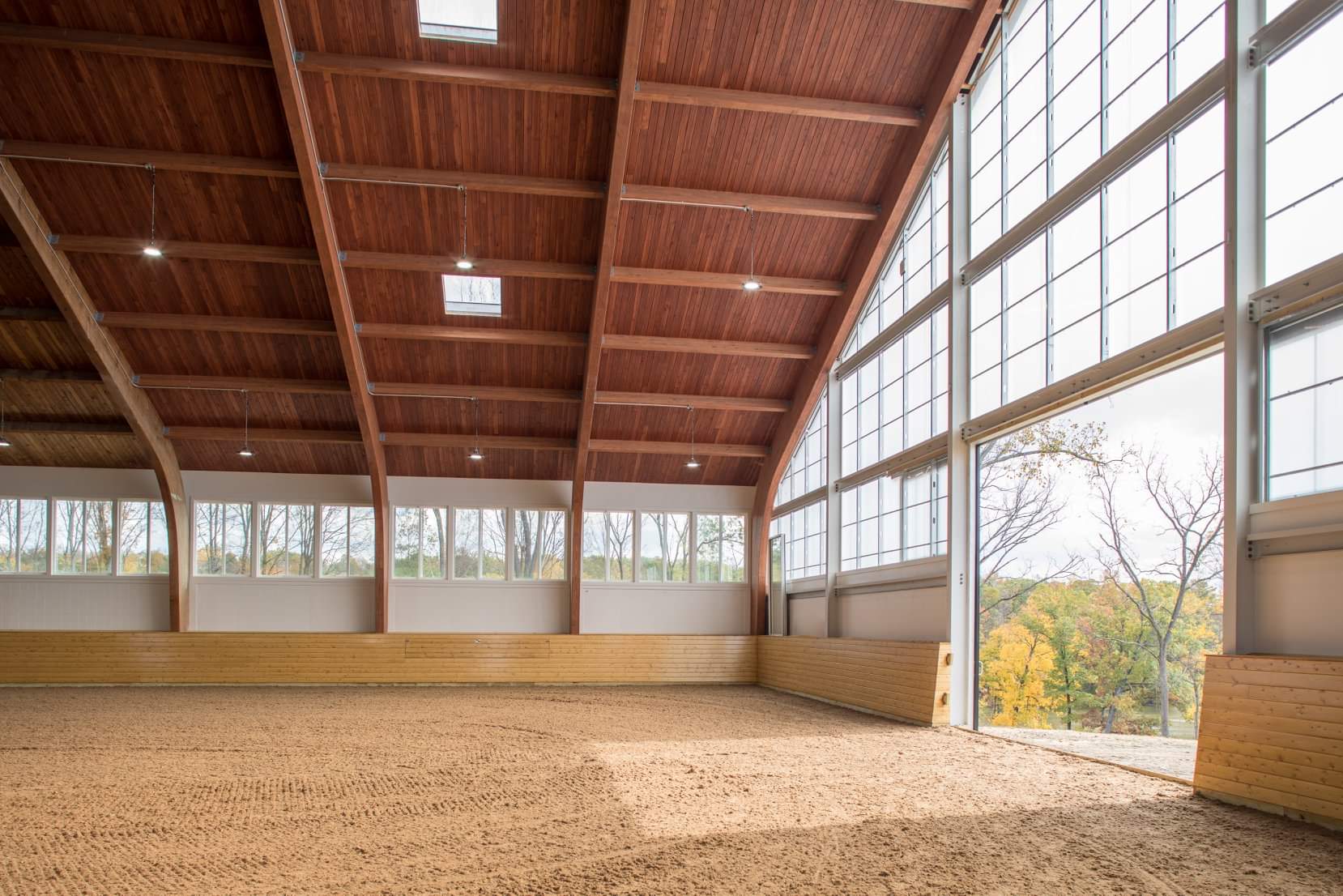 A large barn with a wooden floor and large windows.