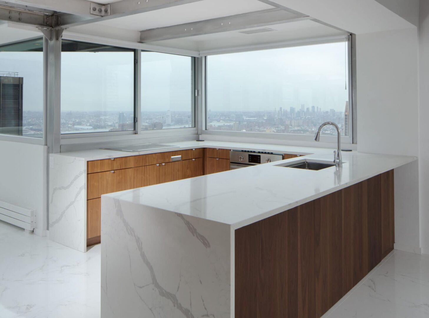 A kitchen with marble counter tops and a view of the city.
