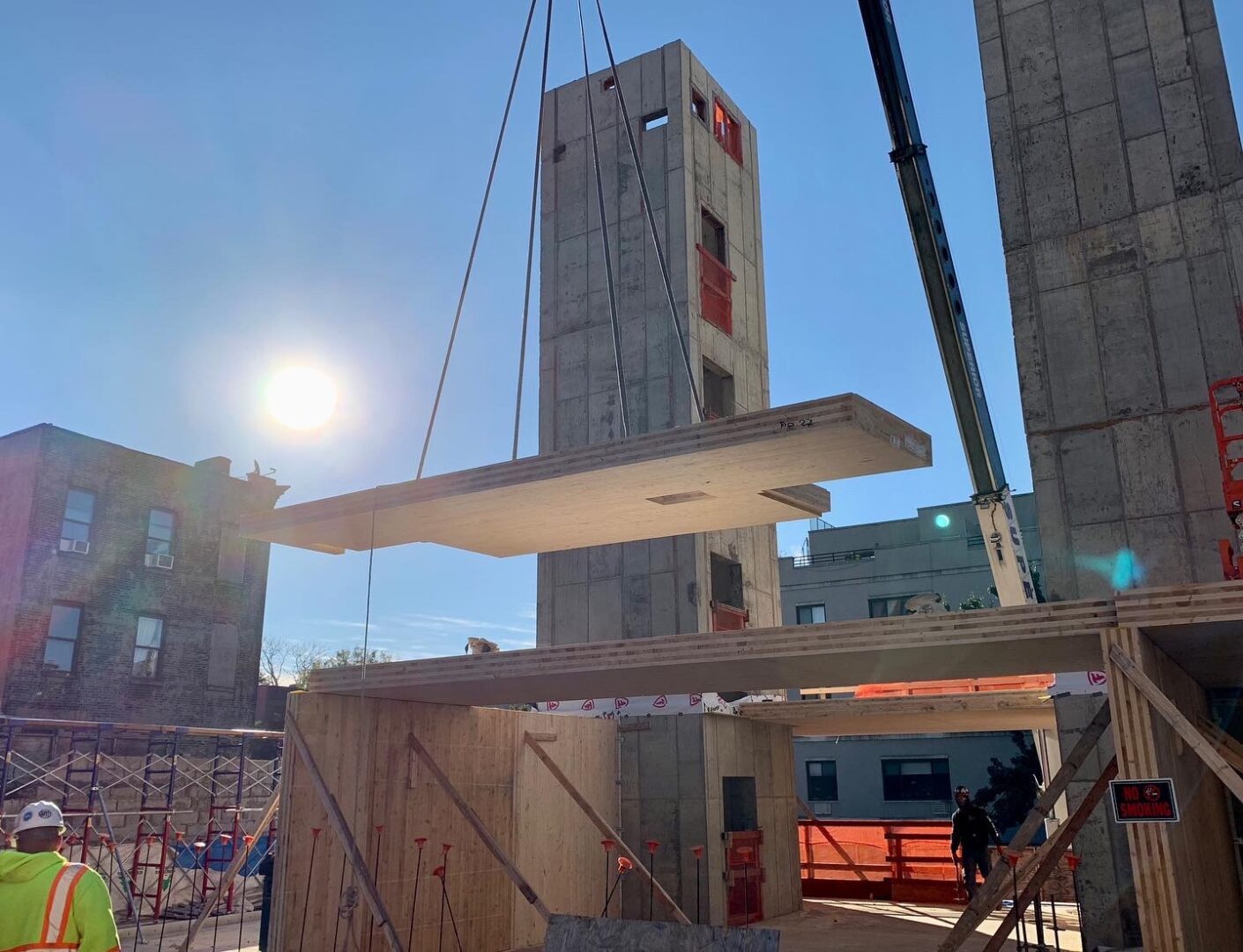 The first Cross Laminated Timber building in New York City utilizes a crane to lift a concrete column into place.