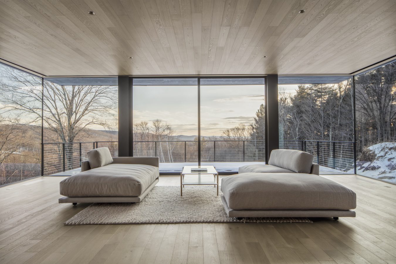 A residential living room with large windows offering breathtaking views of the mountains.